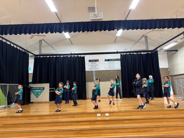 Group of students performing dance on stage