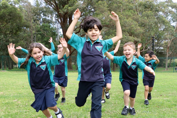 Students running across the grass oval