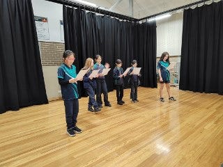 Students rehearsing drama on stage