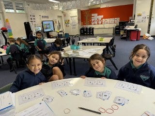 Groups of 4 students at a table in classroom