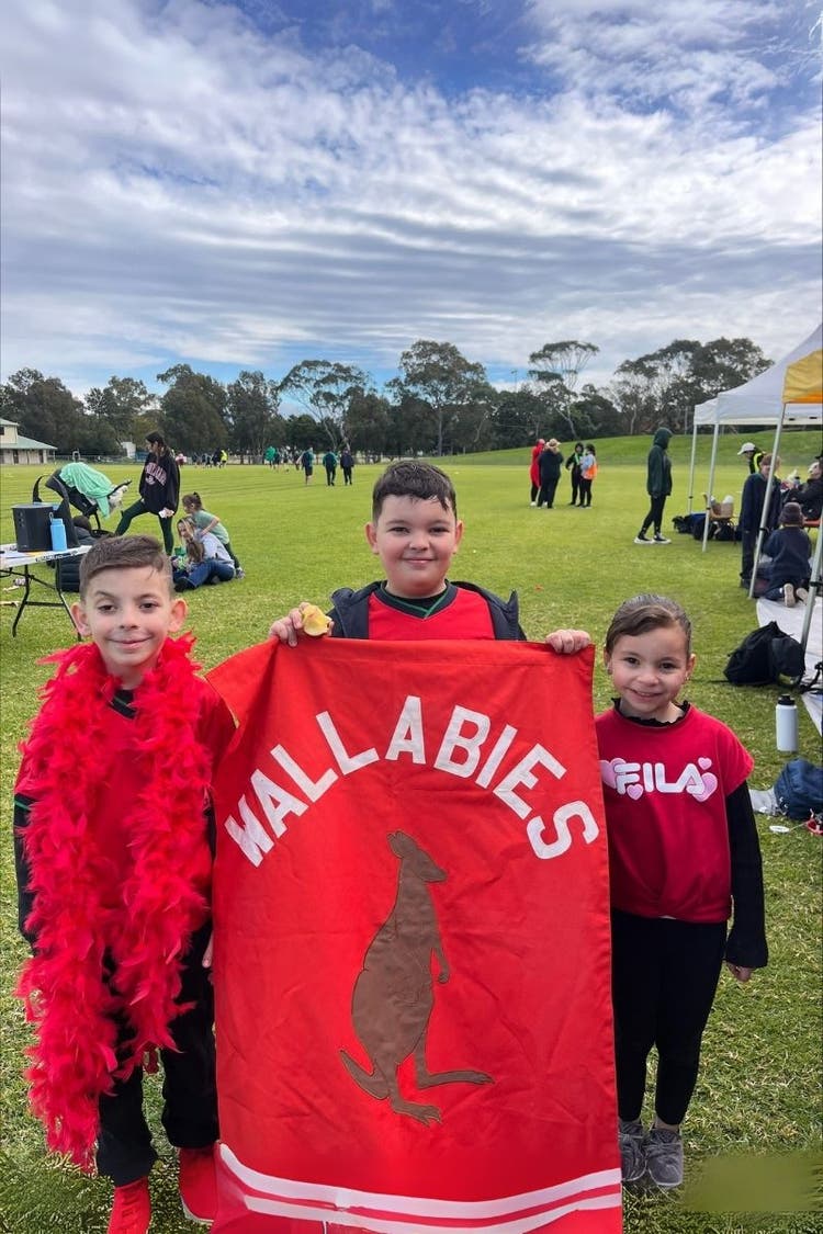 3 children dressed in red sporting house colour