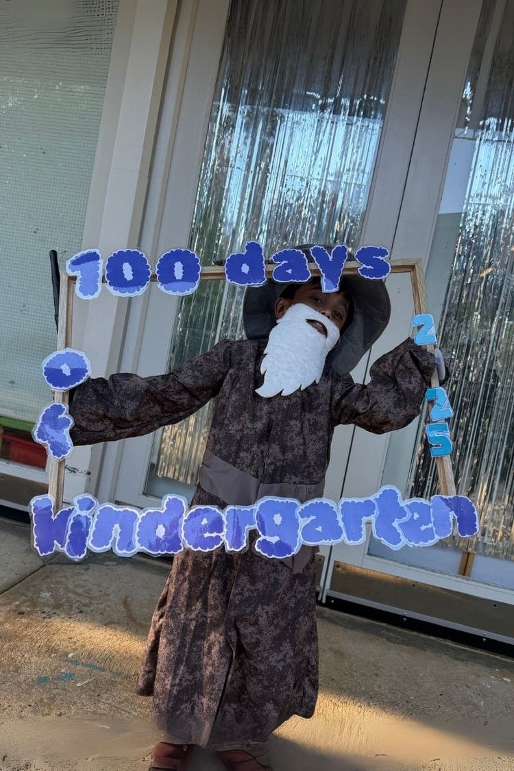 Child dressed as an old man holding a 100 days of kindergarten frame