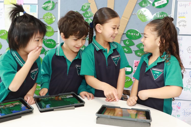 4 kindy students learning and laughing with iPads